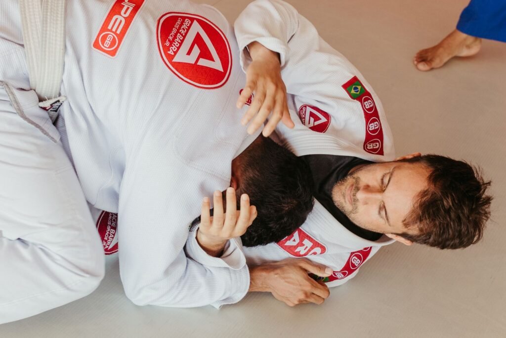 Two Brazilian jiu jitsu practitioners grappling on the mats during training